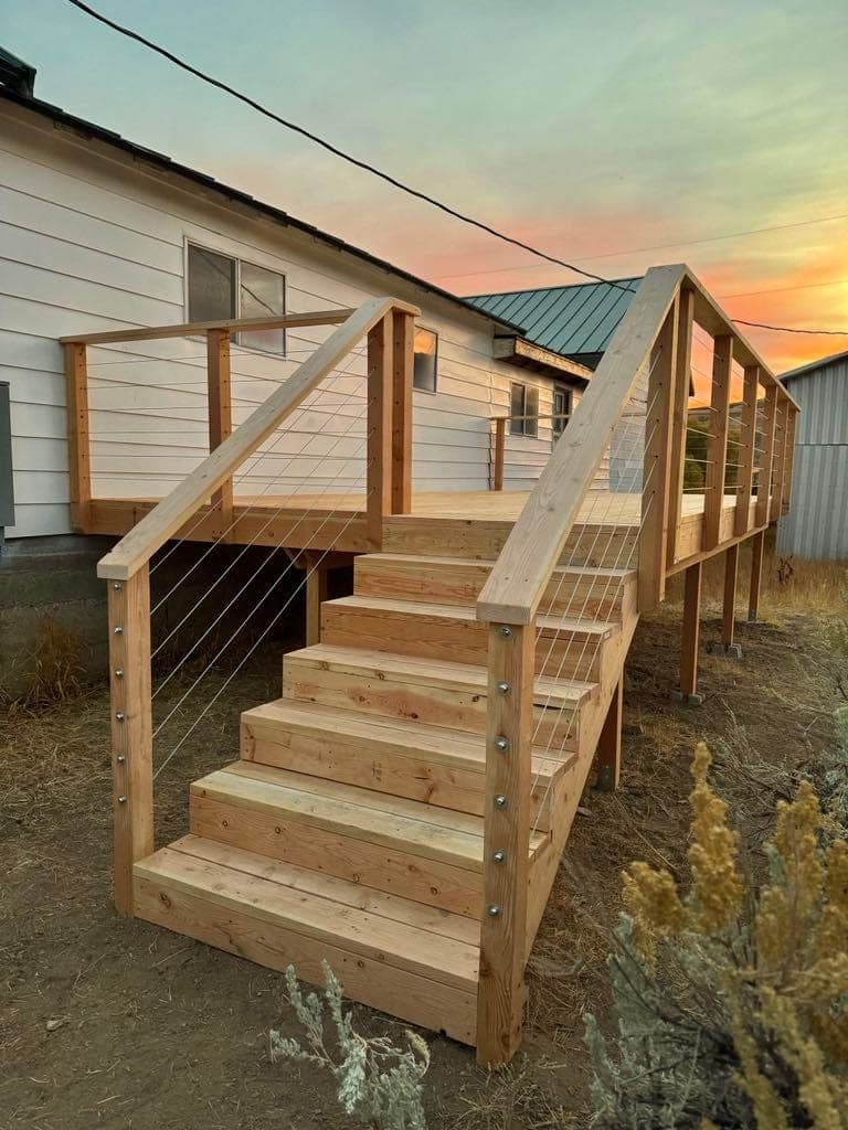 New cedar deck stairs with stainless cable railing at sunset, Elko, Nevada