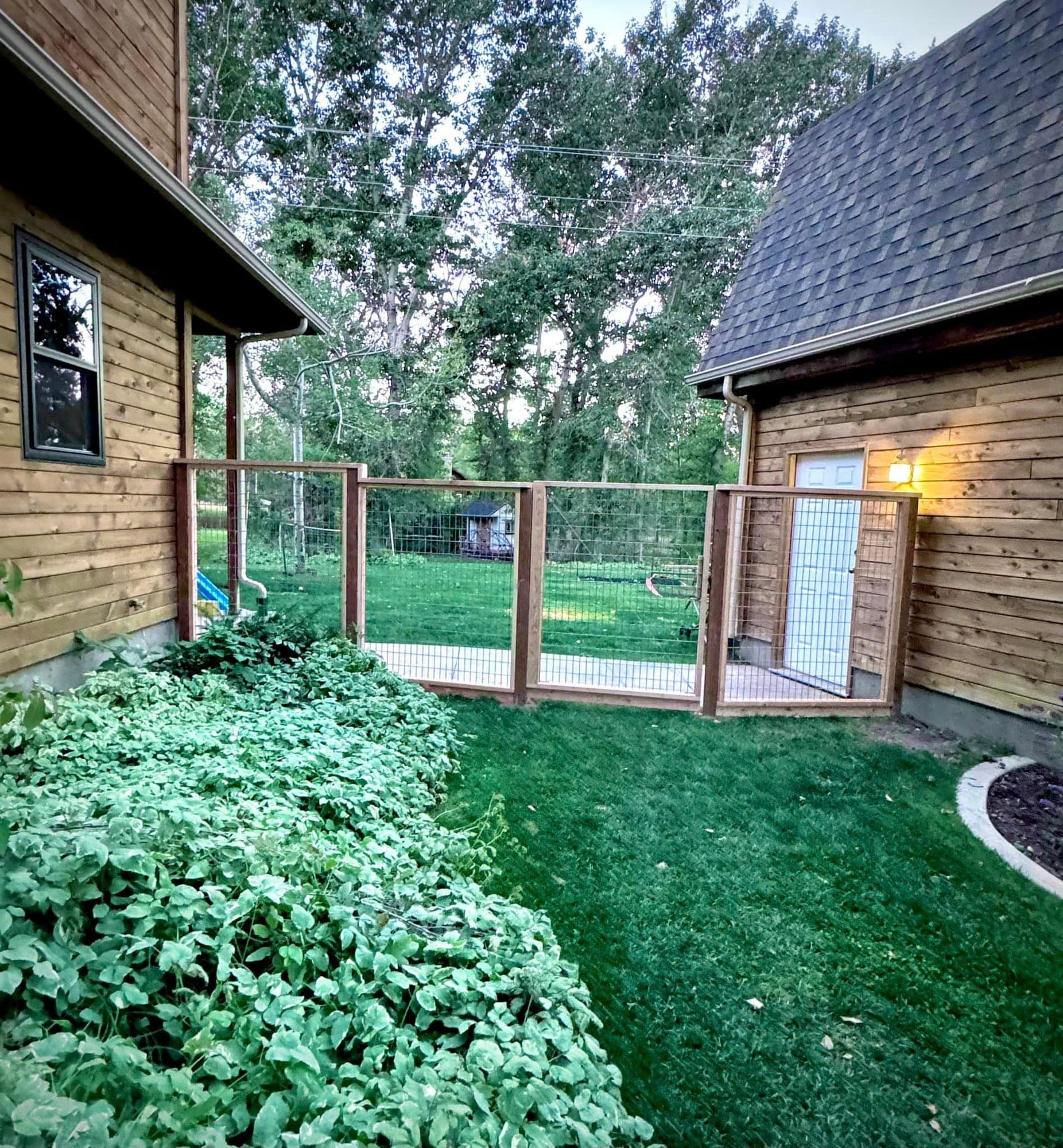 Cedar-framed hog wire fence and walk gate between a cedar-sided house and garage, Elko, Nevada